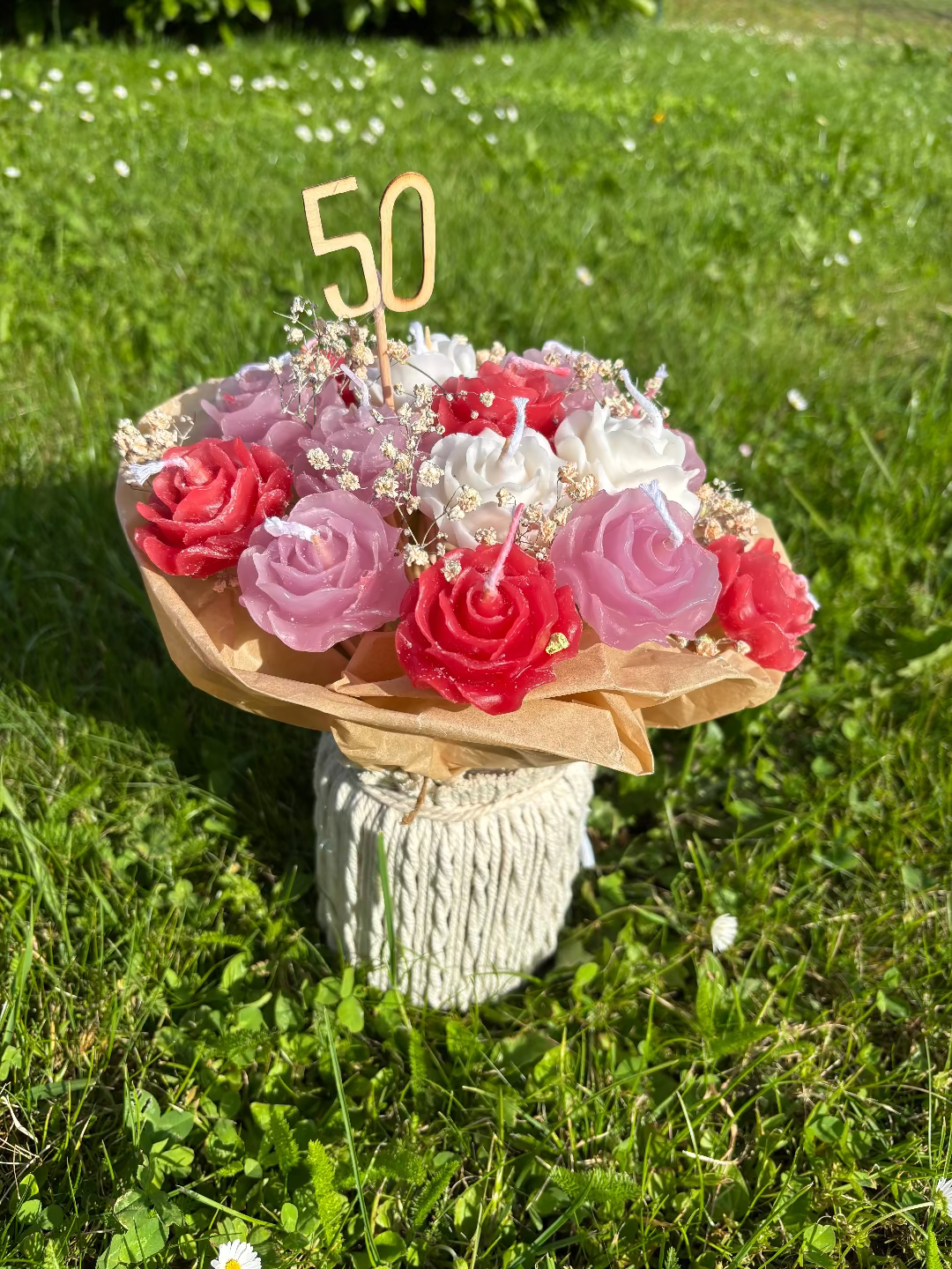 Kerzen, die gemeinsam aussehen wie ein Blumenstrauß aus rot, rosa und weiße Blumenkerzen