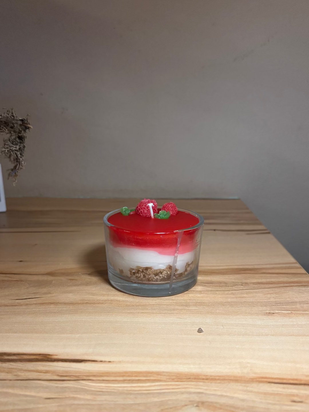 Kerze in einem Glas, die aussieht wie eine Erdbeertorte