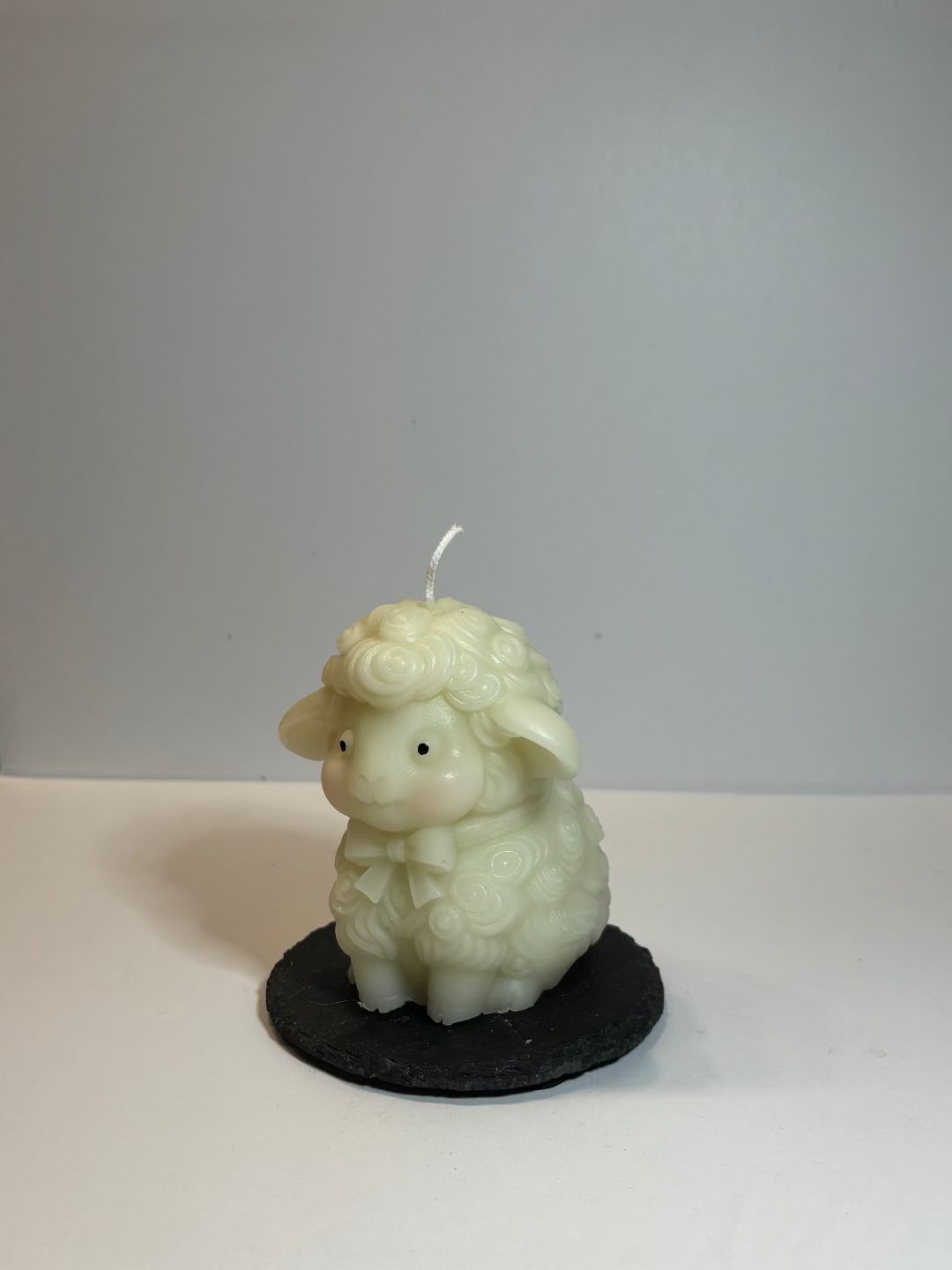 Kerze, die aussieht wie ein riesiges Schaf mit lockiger Wolle und einem netten Gesicht