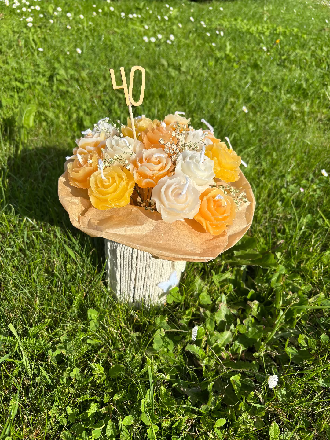 Kerzen, die gemeinsam aussehen wie ein Blumenstrauß aus orange, gelbe und weiße Blumenkerzen