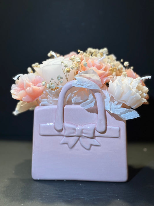 Eine Tasche aus Tonartigem Material, wo Blumenkerzen hineingesteckt sind