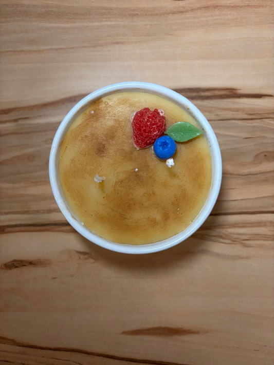 Kerze in einem Glas, die aussieht wie das Dessert Creme Brulee