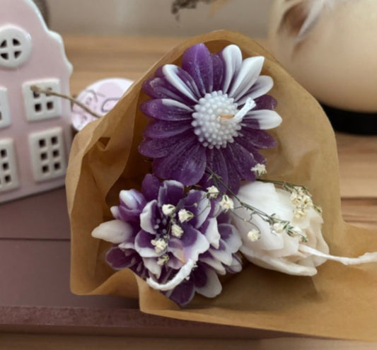 Kerzen, die aussehen wie ein kleiner Blumenstrauss aus drei Kerzen in violett