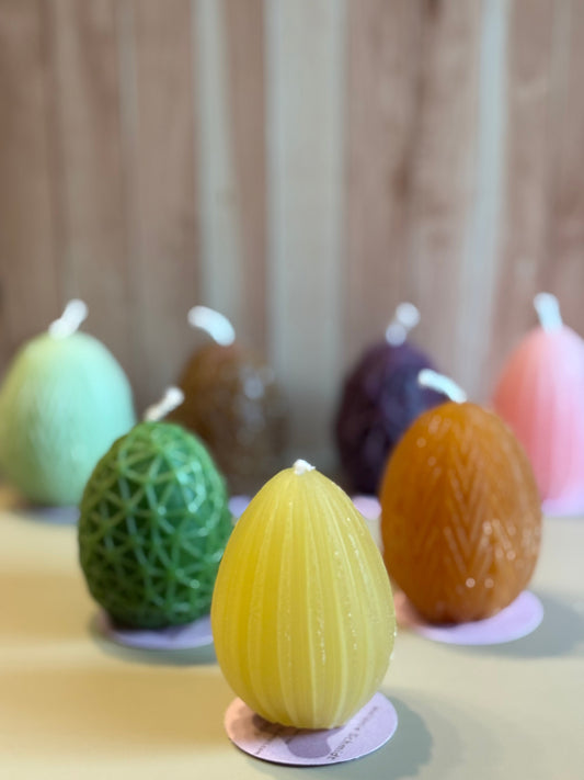 Kerzen, die aussehen wie Eier in verschiedenen bunten Farben, wie gelb, orange, grün, pink, lila
