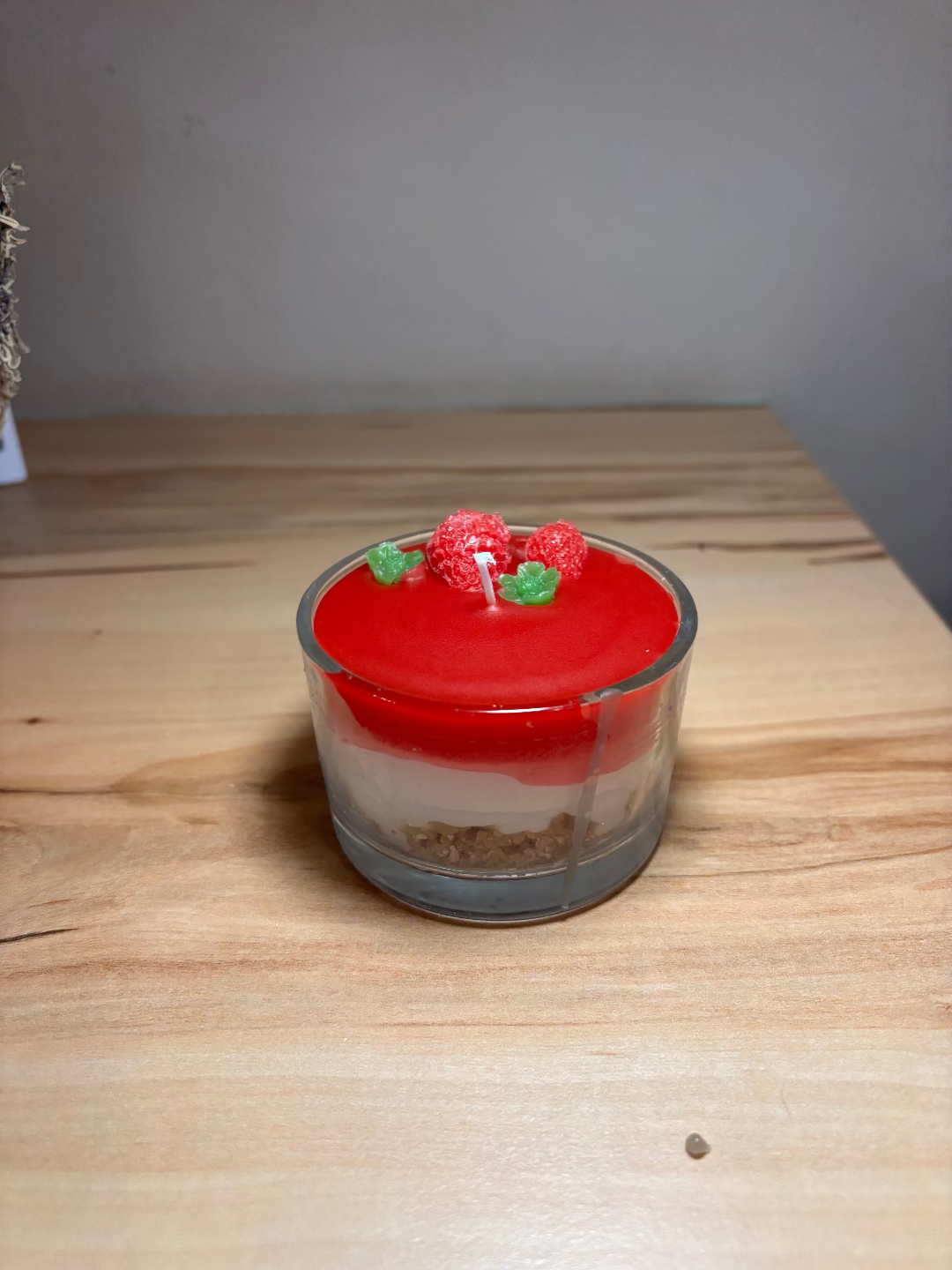 Kerze in einem Glas, die aussieht wie eine Erdbeertorte