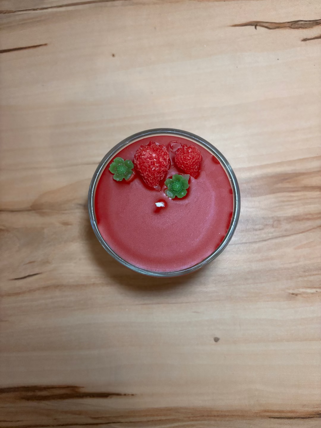 Kerze in einem Glas, die aussieht wie eine Erdbeertorte