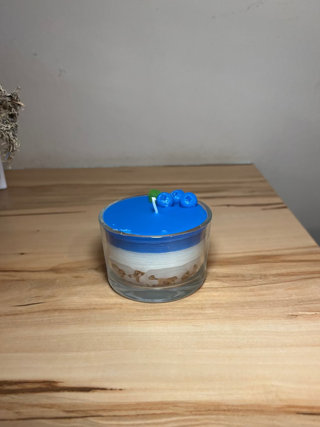 Kerze in einem Glas, das aussieht wie eine Heidelbeertorte