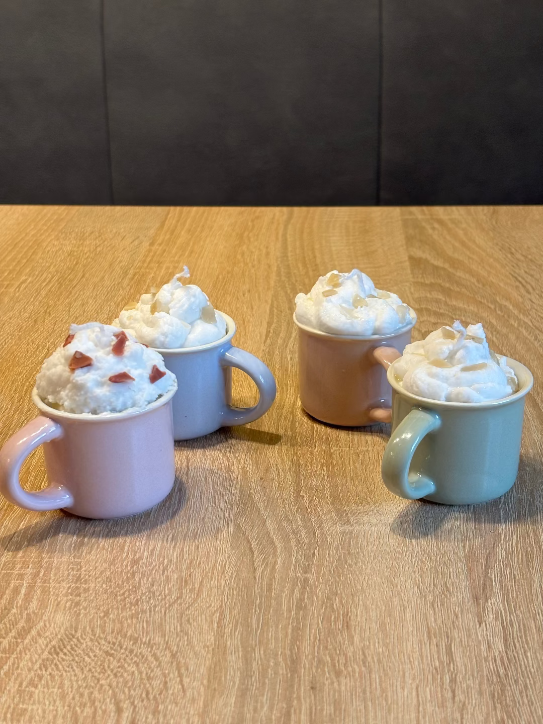Kerze in einer Tasse, die aussieht wie eine heiße Schokolade, wegen der Schlagähnlichen weißen creme 