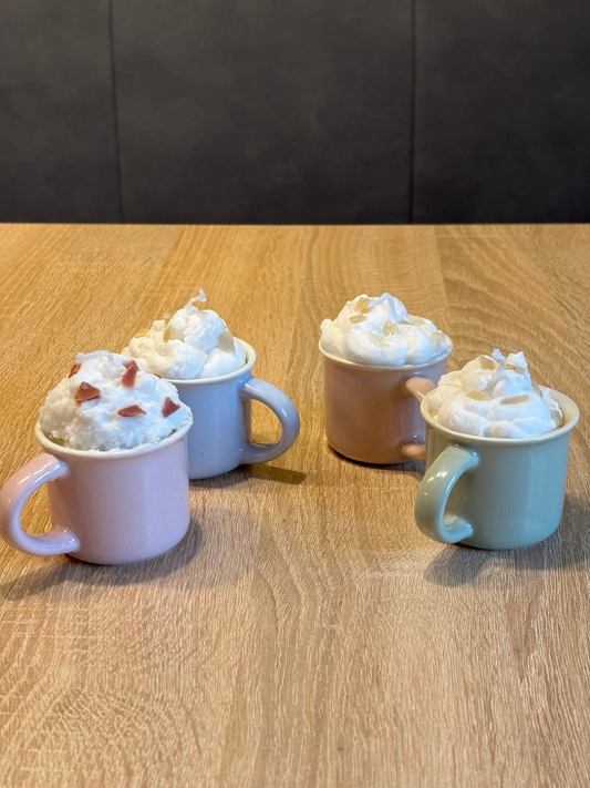 Kerze in einer Tasse, die aussieht wie eine heiße Schokolade, wegen der Schlagähnlichen weißen creme 
