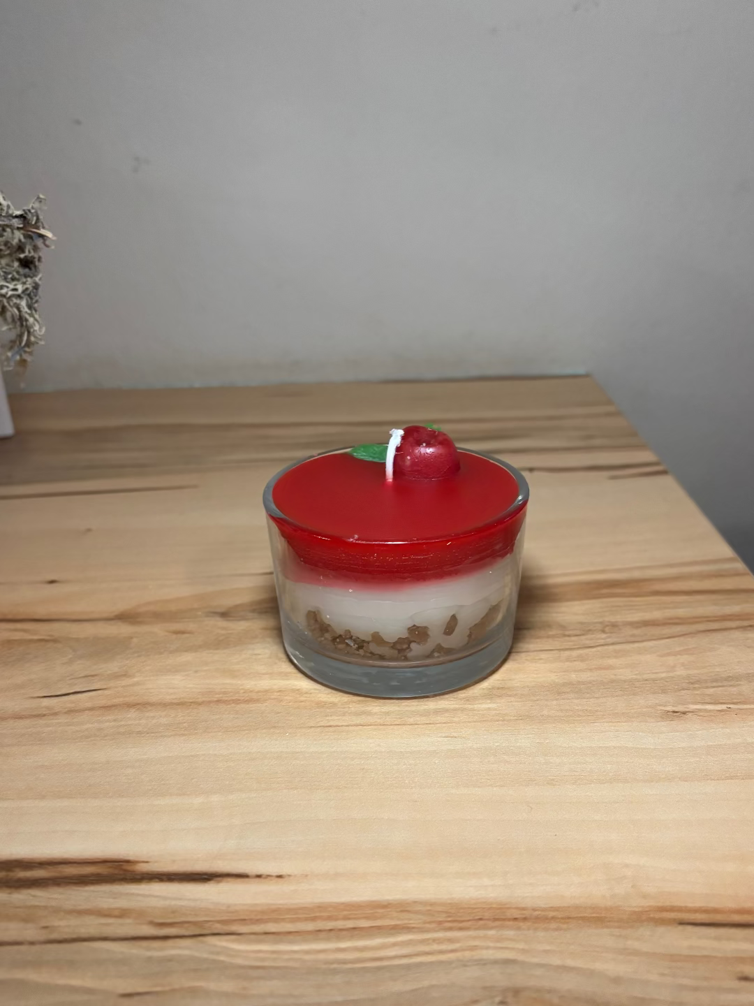 Kerze in einem Glas, die aussieht wie eine Kirschtorte