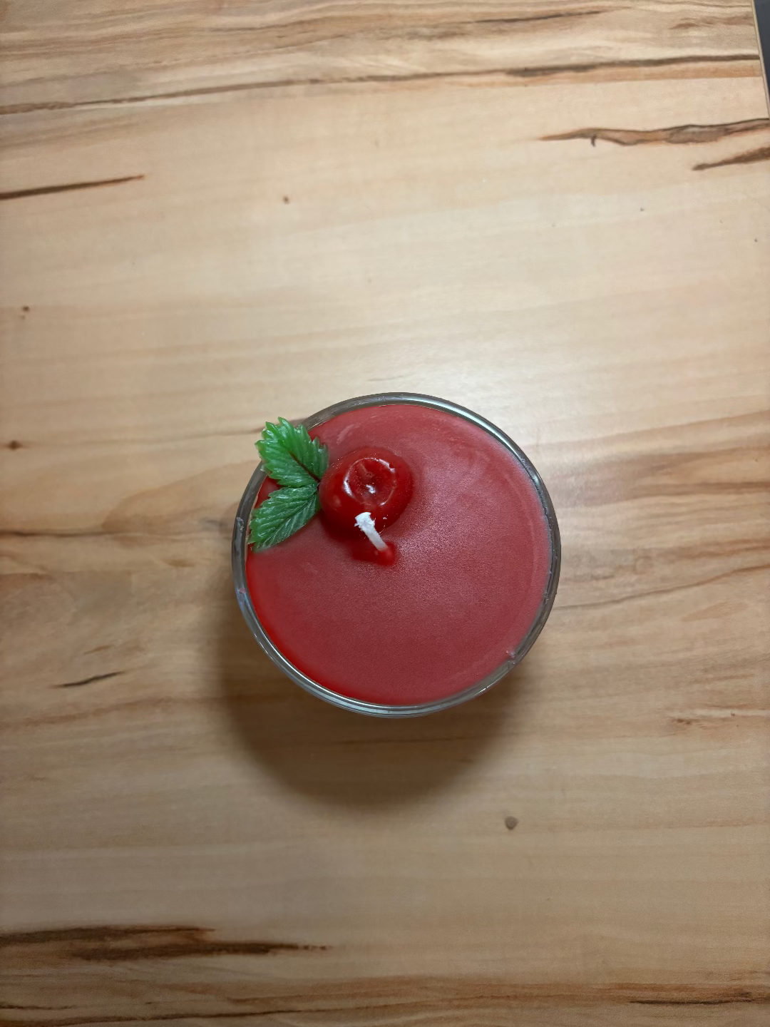 Kerze in einem Glas, die aussieht wie eine Kirschtorte