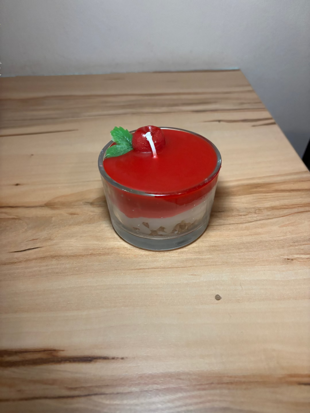 Kerze in einem Glas, die aussieht wie eine Kirschtorte