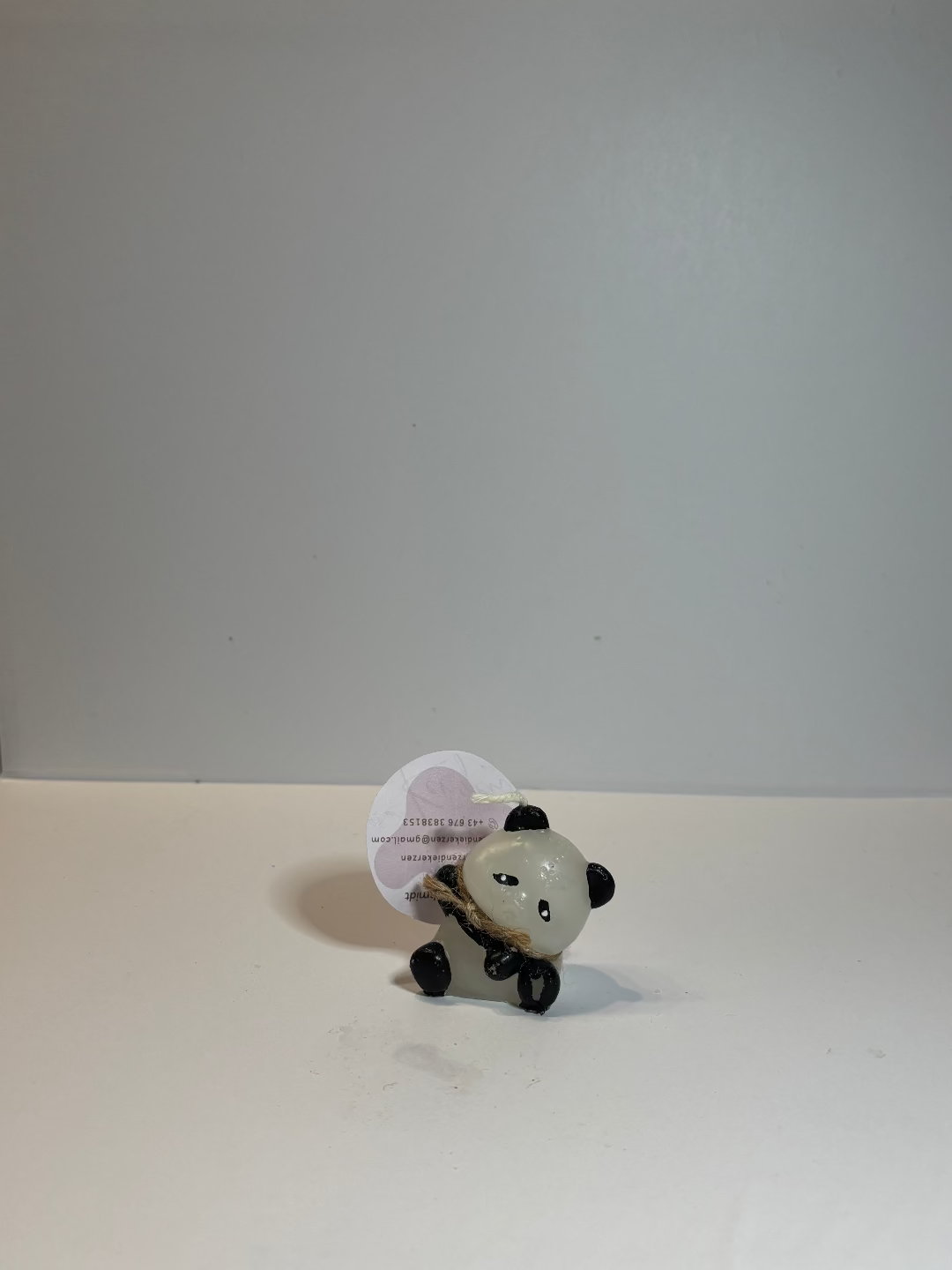 Kerze, die aussieht wie ein winkender Pandabär