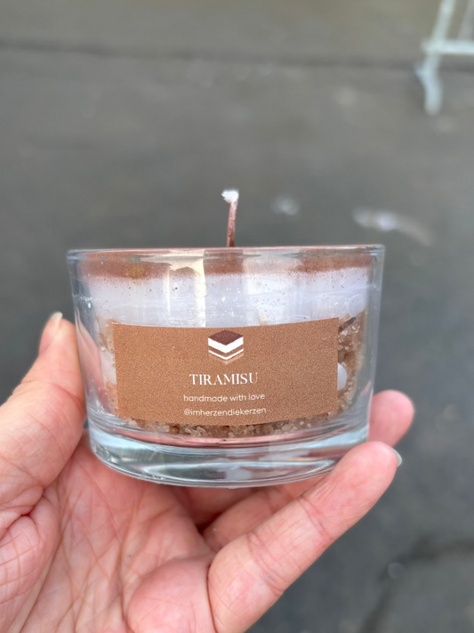 Kerze in einem Glas, das aussieht wie das Dessert Tiramisu