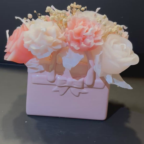 Video, indem man eine Tasche aus tonartigem Material, worin Blumenkerzen gesteckt sind, sieht