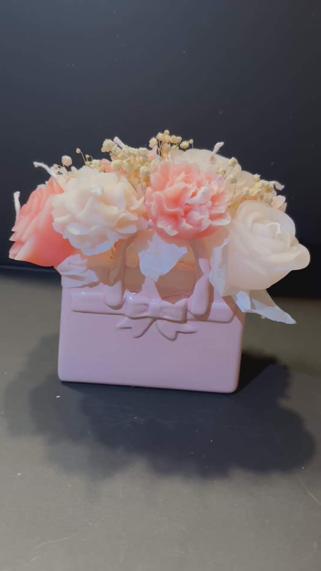 Video, indem man eine Tasche aus tonartigem Material, worin Blumenkerzen gesteckt sind, sieht